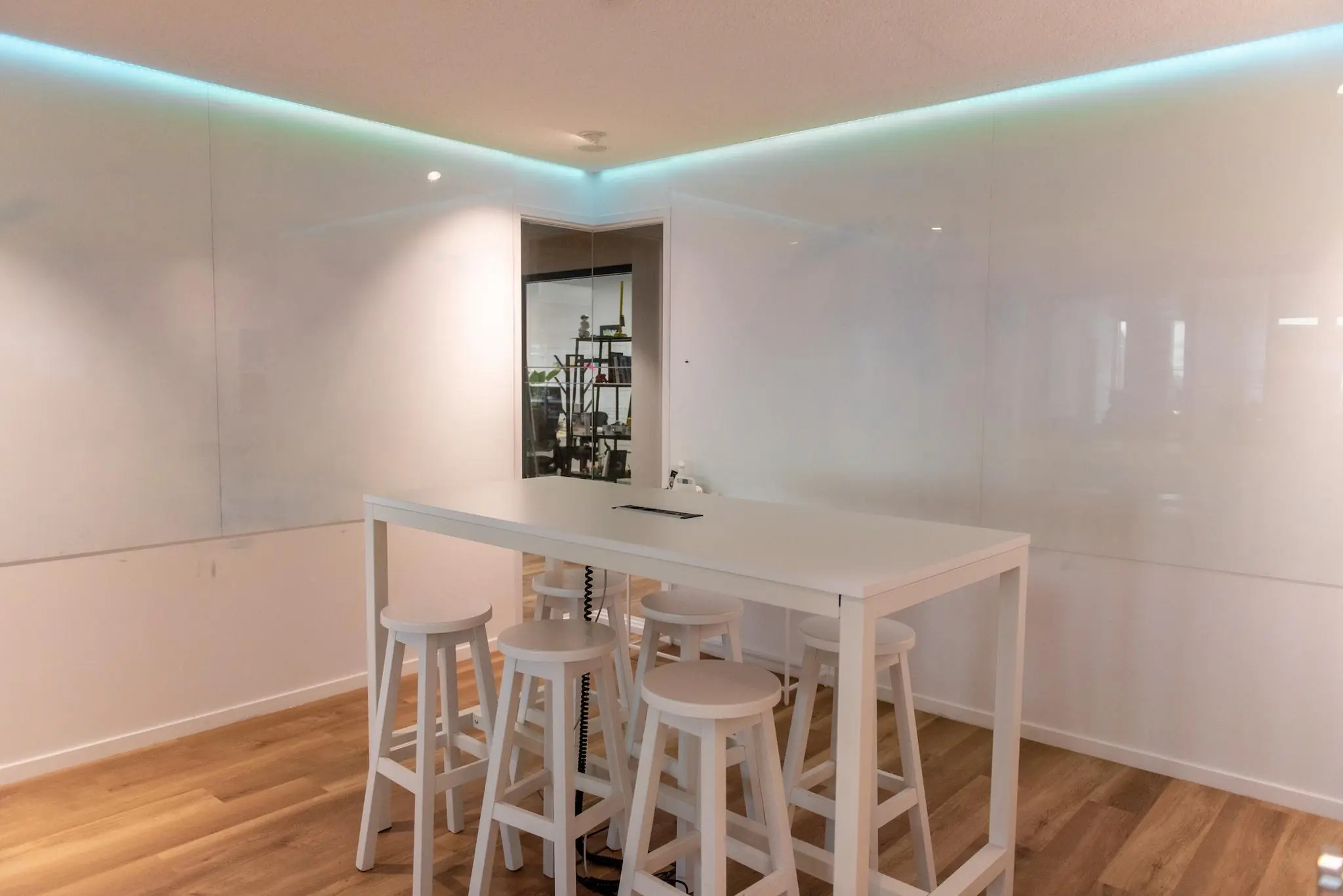 Moderne vergaderruimte aan de Aert van Nesstraat met hoge witte tafel, krukken en glazen wanden.